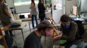 Besucherinnen und Besucher schauen sich Bilder über Leinwand und Monitor an.