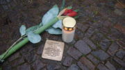 Stolperstein, mit Kerze und Blume.