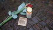 Stolperstein, mit Kerze und Blume.