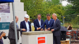 Fünf Herren stehen um einen Betonblock herum.